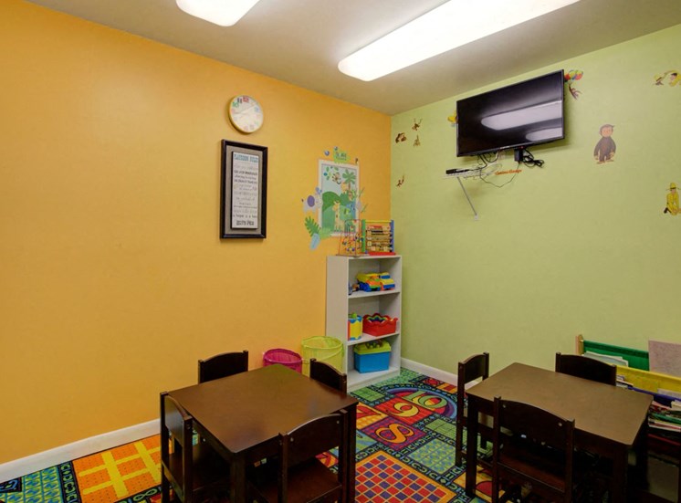 Colorful Activity Room with Small Tables and Mounted TV
